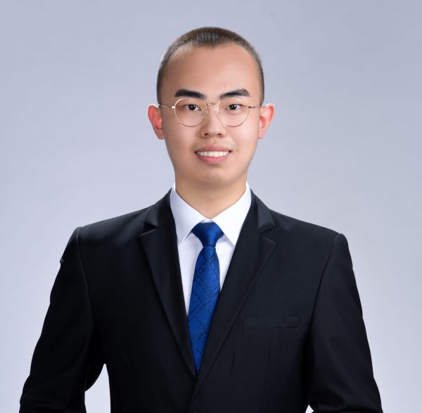 Ke Xu wearing a black suite and a blue tie